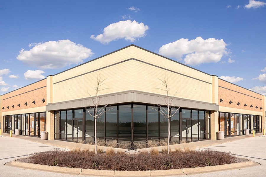 Business Insurance - New Commercial Retail Building Against Blue Sky
